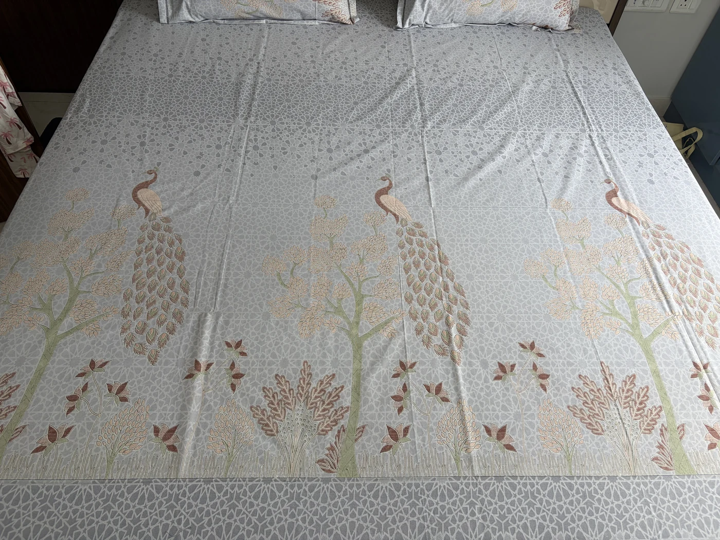 Ghoomer Pure Cotton King seen closer in, showing the printed peacocks, trees and leaf motifs across the sheet