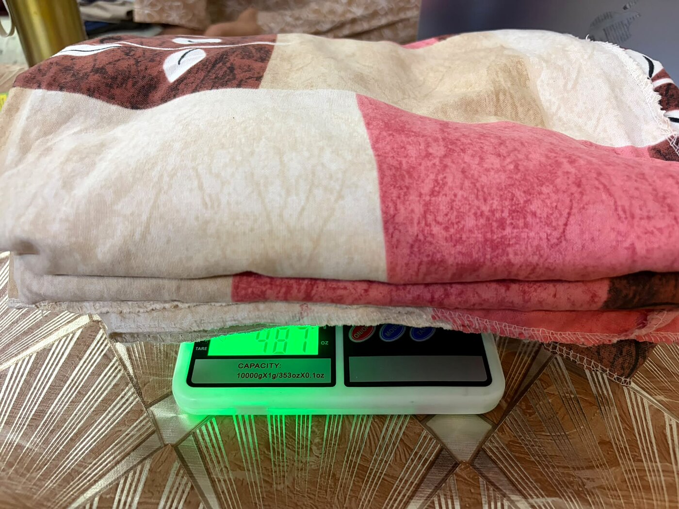 Budget queen bedsheet on weighing scale showing only 487 grams
